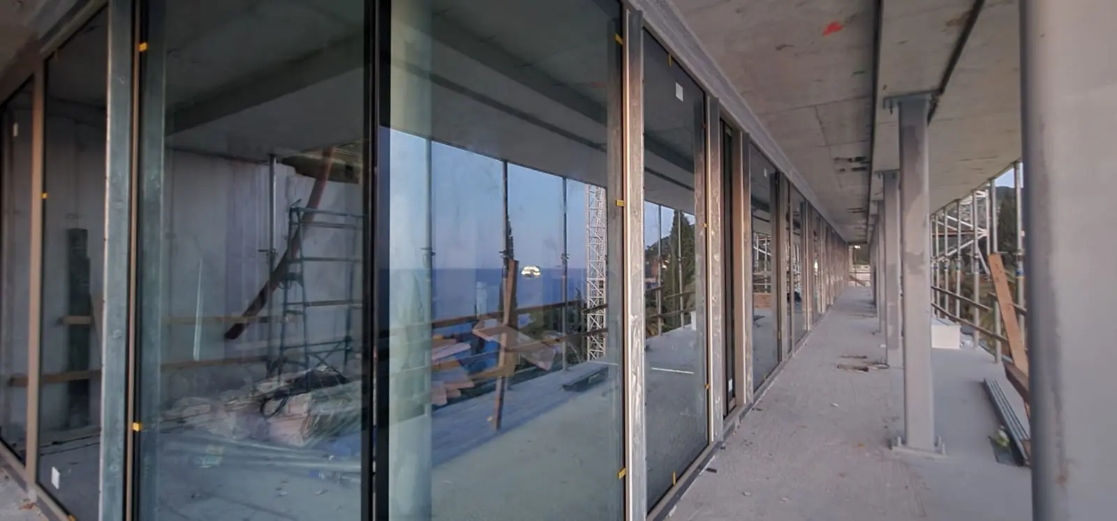 Zgrada u izgradnji Archicon Split s velikim staklenim stijenama i pogledom na more.