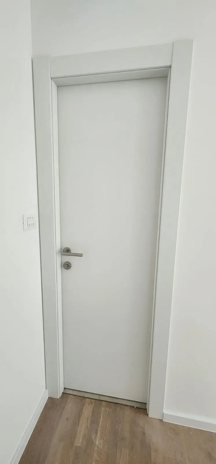 Bijela unutarnja vrata s modernom kvakom i drvenim podom, Archicon Split