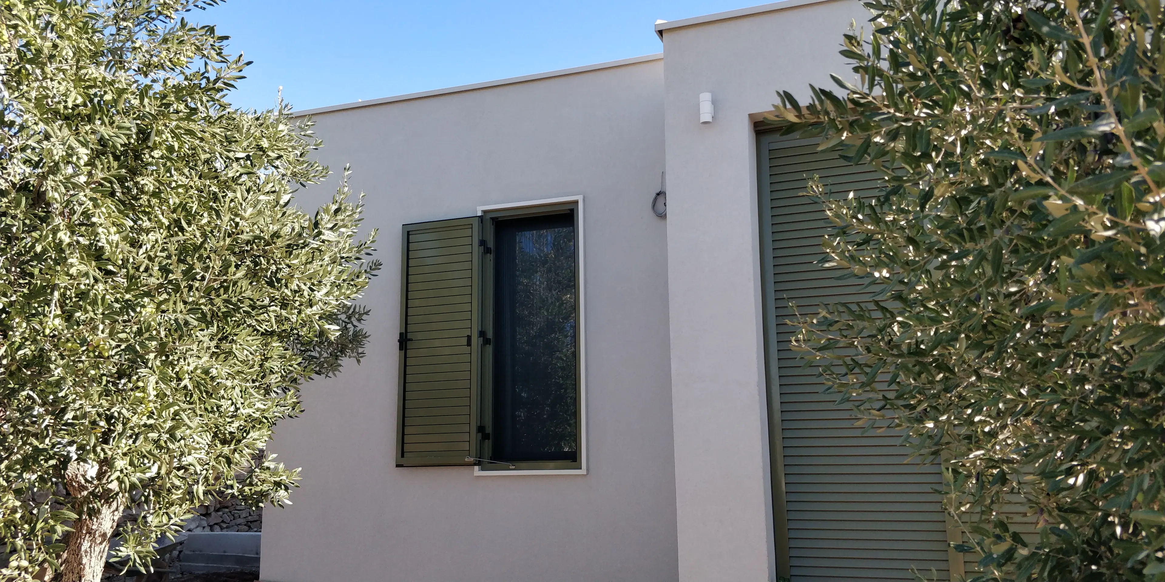 Moderna kuća Archicon Split s maslinama, otvorenim zelenim griljama i plavim nebom