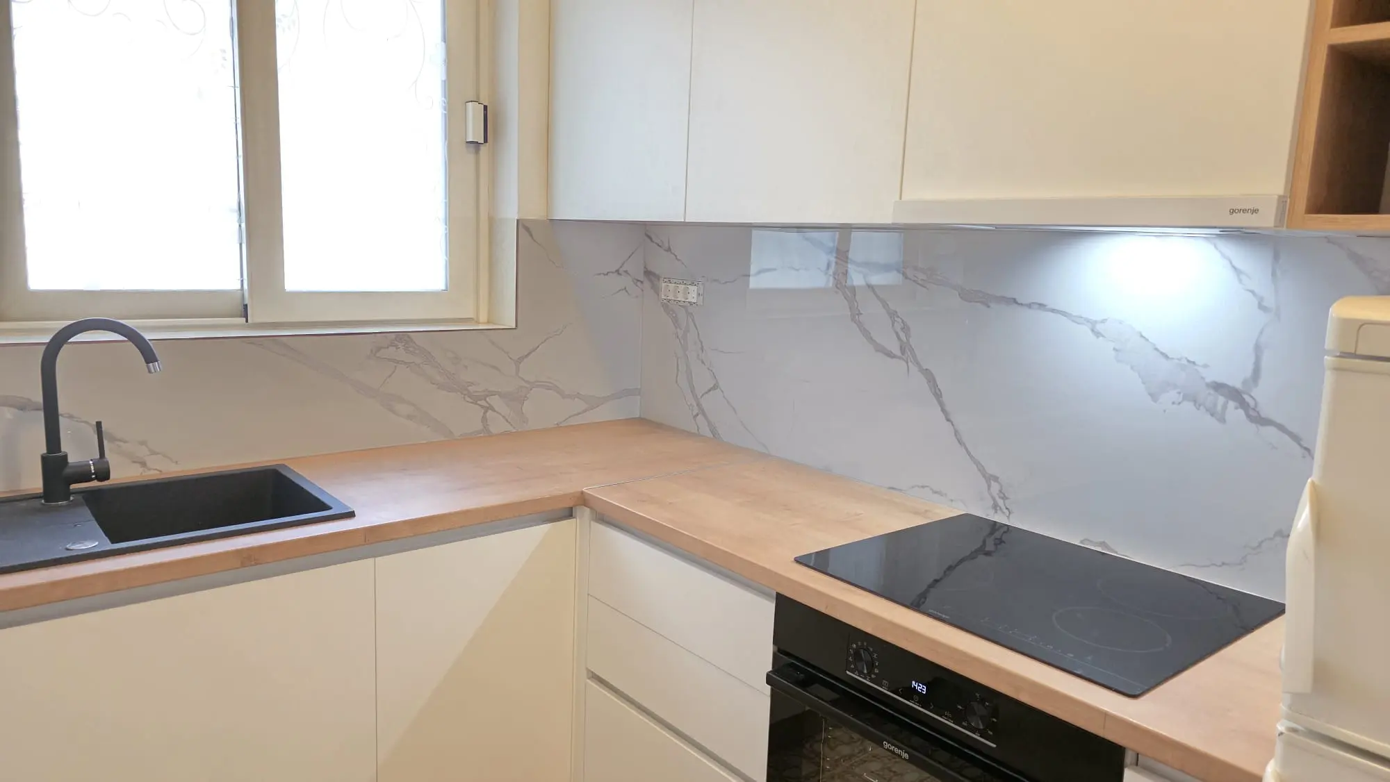Moderna kuhinja s drvenom radnom pločom, crnim sudoperom i mramornim zidnim oblogama, Archicon Split.