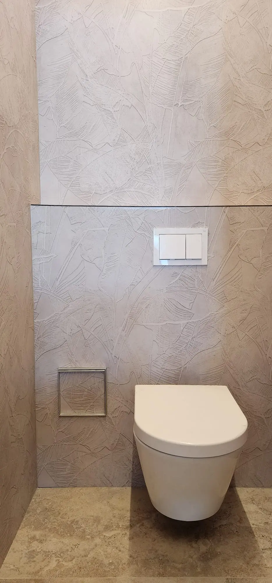Moderna zidna WC školjka s bijelom tipkom za ispiranje i dekorativnim zidom s uzorkom lišća, Archicon Split.