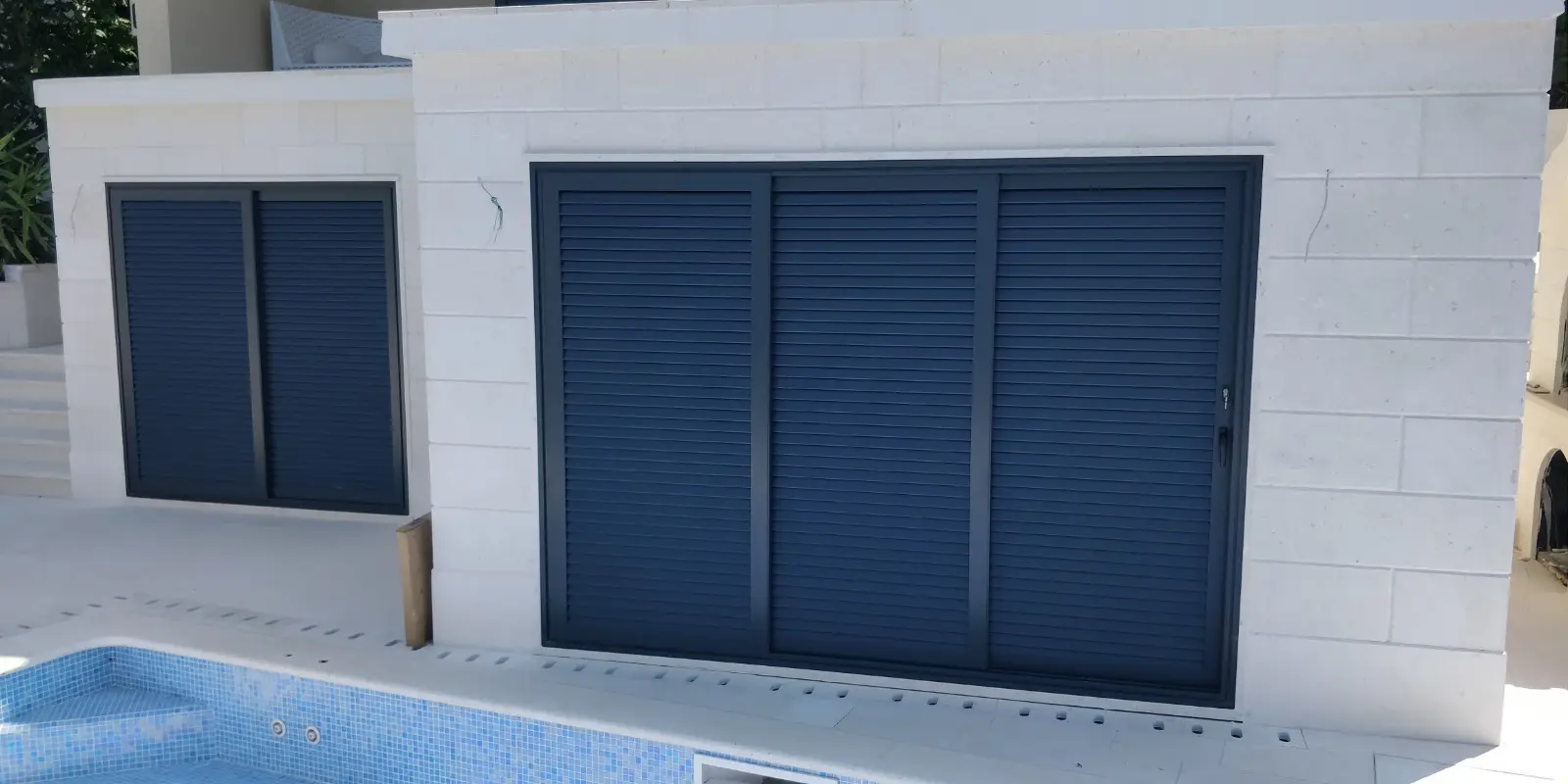 Moderna zgrada s bijelim ciglama, tamnoplavim kliznim griljama i bazenom s plavim mozaikom, Archicon Split
