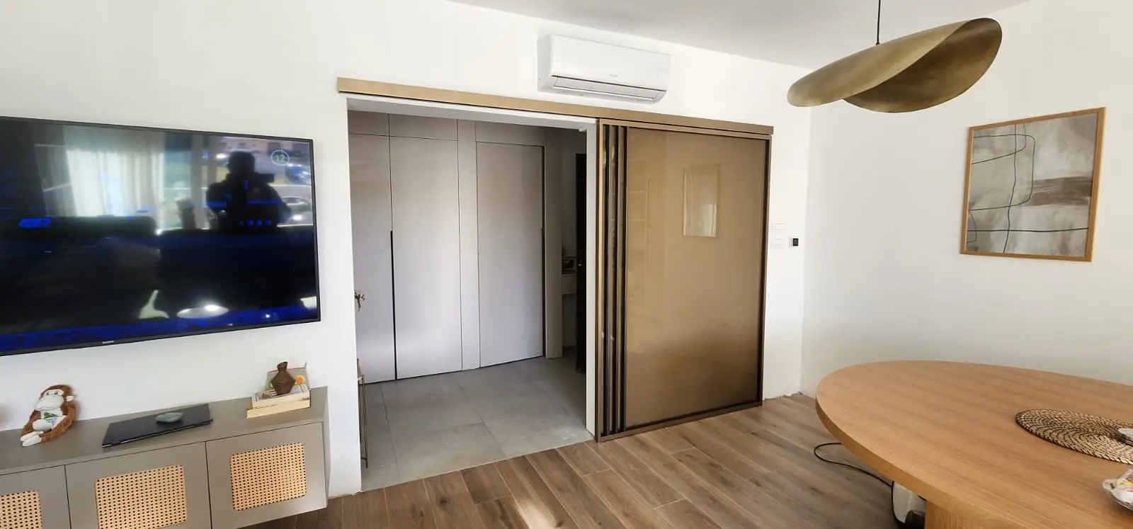 Moderni dnevni boravak s TV-om, kliznim vratima i drvenim podom, dizajn Archicon Split
