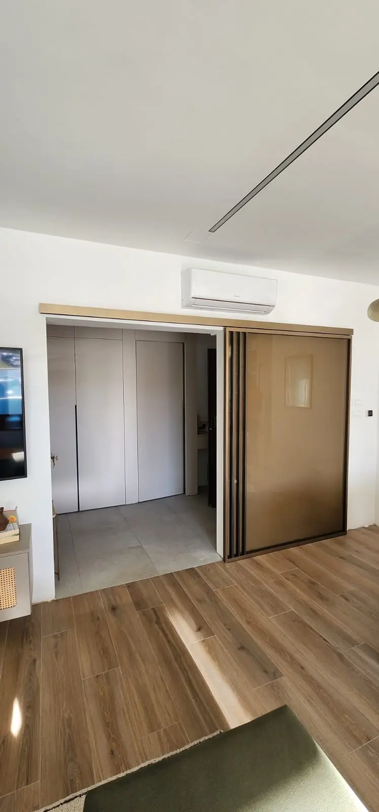 Moderni interijer s drvenim podom, kliznim vratima od zatamnjenog stakla i ugradbenim ormarima, Archicon Split