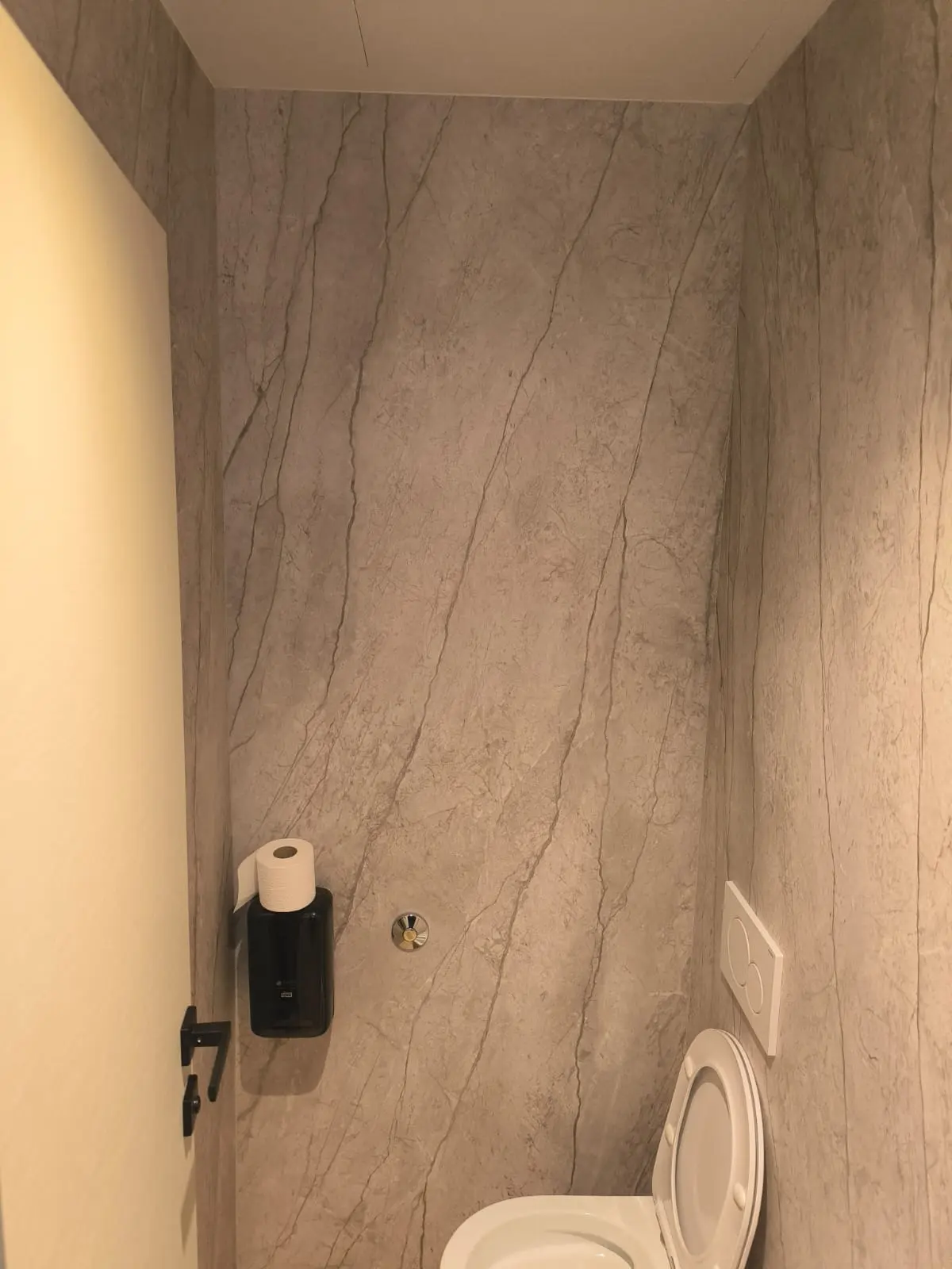 Moderni WC s elegantnim zidnim oblogama imitacije mramora i bijelom sanitarijom Archicon