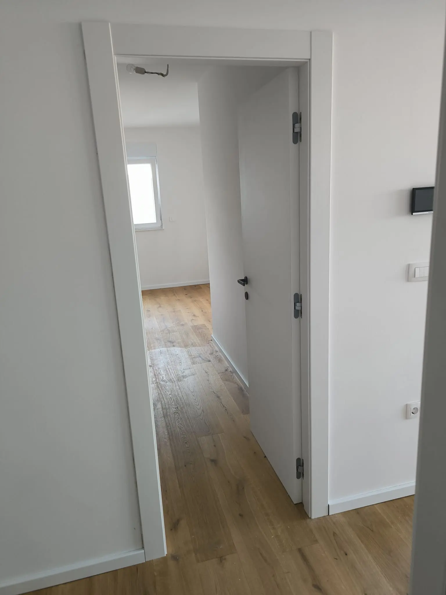 Otvorena bijela vrata u modernom interijeru s drvenim podom, Archicon Split