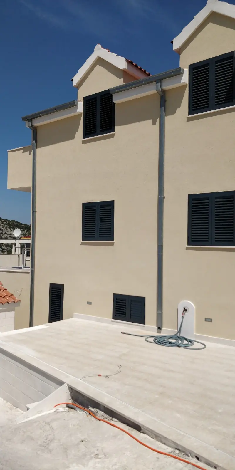 Svjetložuta zgrada s tamnim griljama i ravnim krovom, projekt Archicon Split