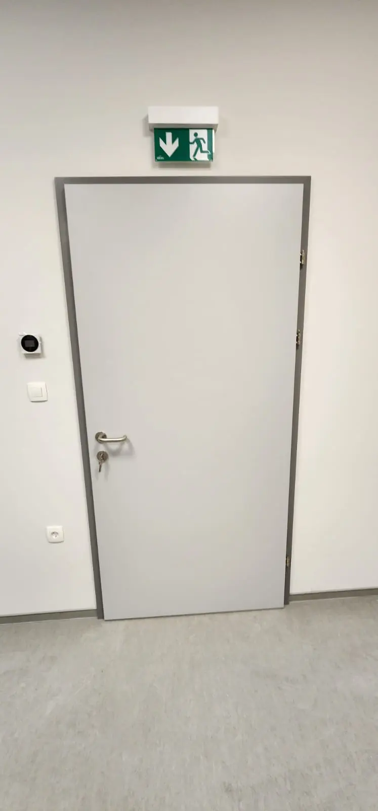 Svijetla vrata s ključem, znakom za izlaz u nuždi i senzorima u uredu Archicon Split.