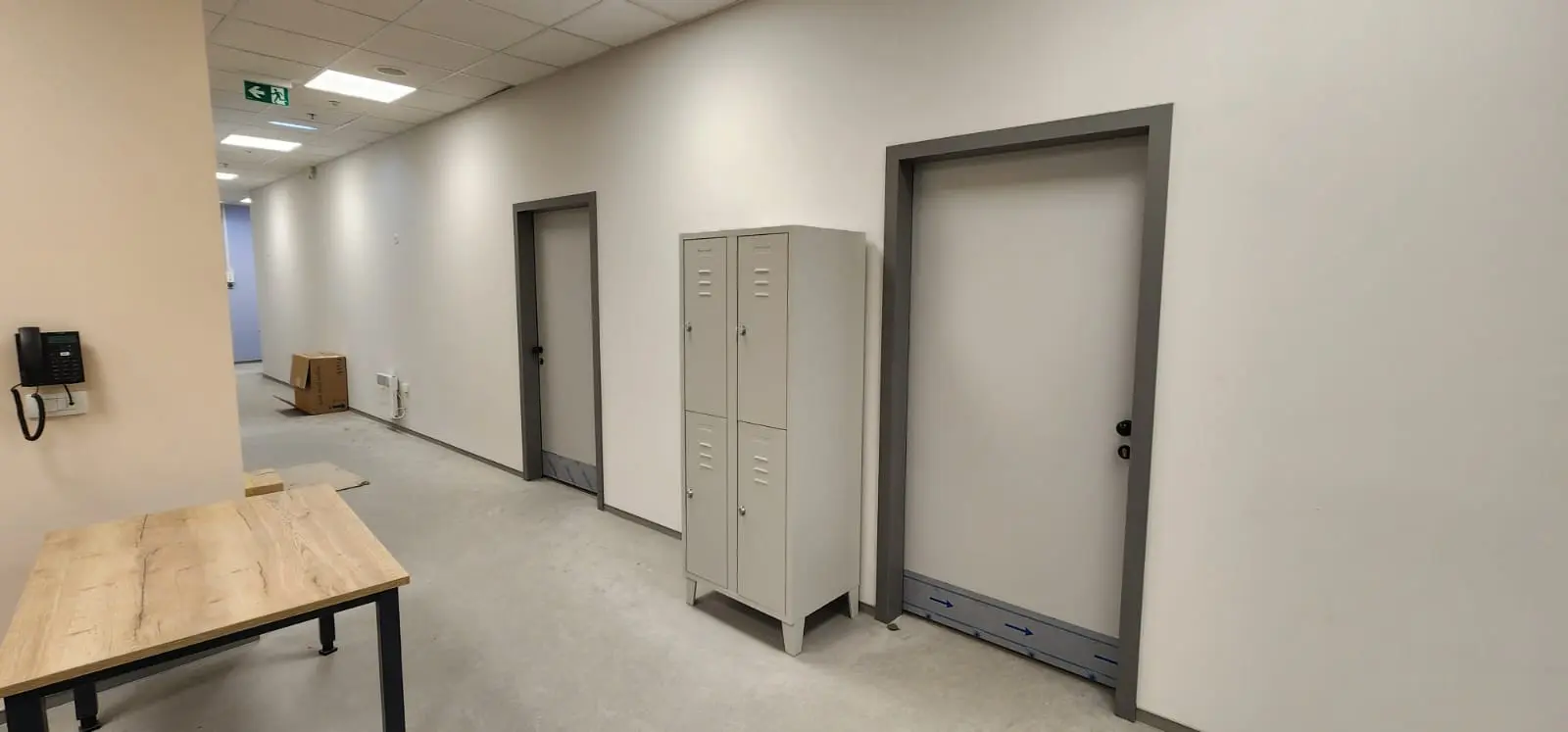 Moderni uredski hodnik s metalnim ormarićima, vratima i stolom, projekt Archicon Split.